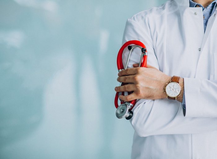 Young handsome physician in a medical robe with stethoscope